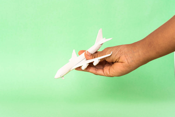 hand houden speelgoed vliegtuig tegen kleur achtergrond   - Foto, afbeelding