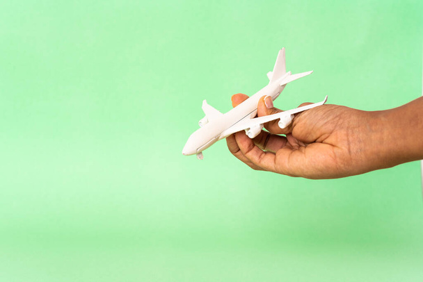 χέρι κρατώντας το παιχνίδι αεροσκαφών με φόντο το χρώμα   - Φωτογραφία, εικόνα