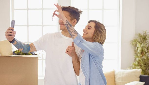 Glücklich lächelndes junges Paar zeigt ein Schlüsselpaar ihres neuen Hauses - Foto, Bild