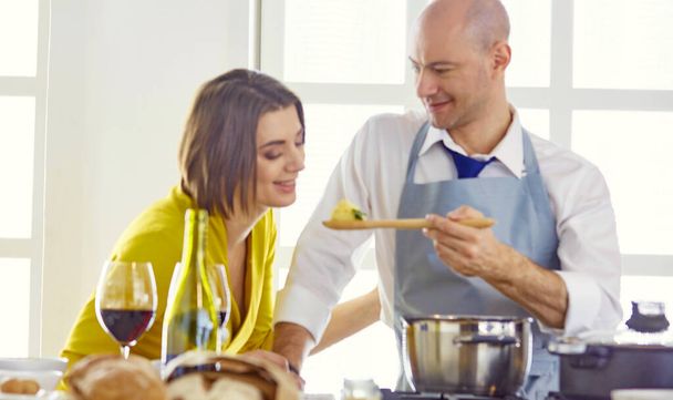 Smiling young couple cooking food in the kitchen - Photo, Image
