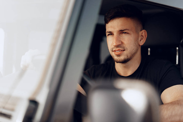 Handsome young man driver looking through the window of his off-road car - Fotografie, Obrázek