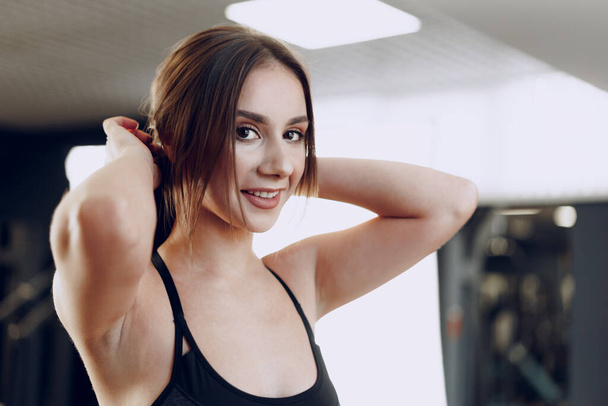 Portrait of a young sporty caucasian woman training in a fitness club - Photo, image