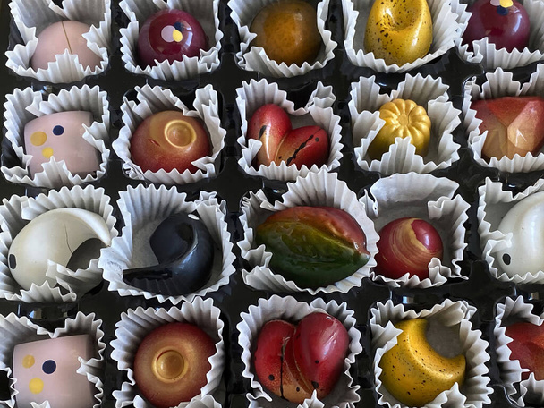Doboz színes csokoládék kraft papír háttér, ünnepi étel, édes romantikus ajándék - Fotó, kép