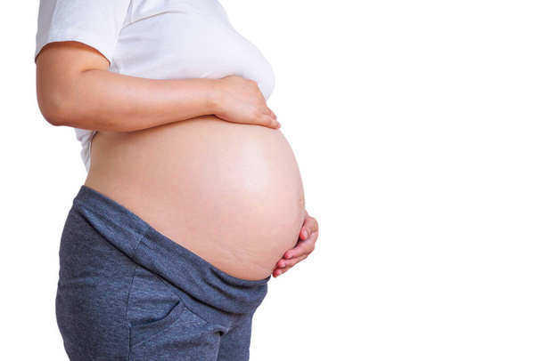 raskaana oleva nainen koskettaa hänen vatsa eristetty valkoisella taustalla - Valokuva, kuva