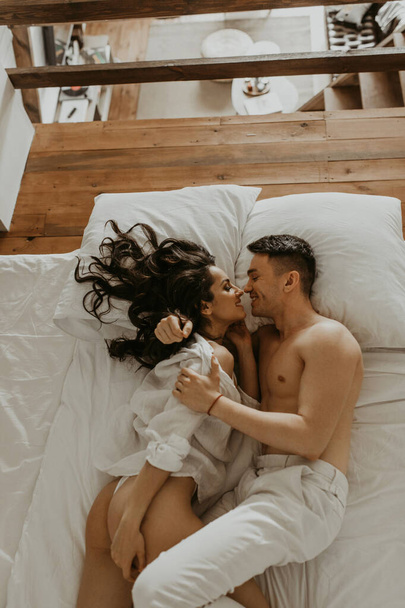 Beautiful loving couple kissing in bed - Fotó, kép