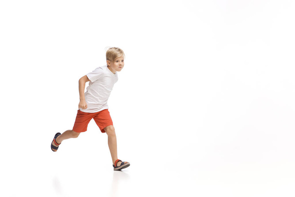 Happy little caucasian boy jumping and running isolated on white background - 写真・画像
