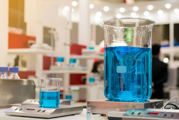 科学のための磁気攪拌機またはミキサーマシン上のビーカー実験室フラスコ中の美しい渦青カラフルな化学液体の閉じる - 写真・画像