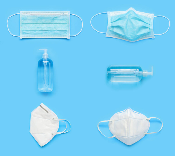 N95 Máscara facial médica con gel desinfectante de alcohol botella de lavado a mano sobre fondo azul covid-19 Concepto de prevención de Coronavirus minimalista plano lay estilo creativo - Foto, Imagen