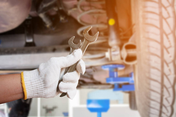 Car mechanic holding wrench at the car repair service garage - Foto, Imagem