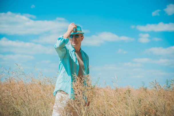 Mature man at field, lifestyle older men. Older senior man wear blue skirt and hat, casual style at field - Фото, зображення