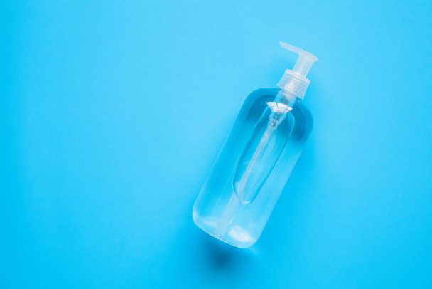 Alkohol-Händedesinfektionsgel-Flasche auf blauem Hintergrund schützt vor COVID-19 Coronavirus. Gesundheitswesen und medizinisches Konzept - Foto, Bild