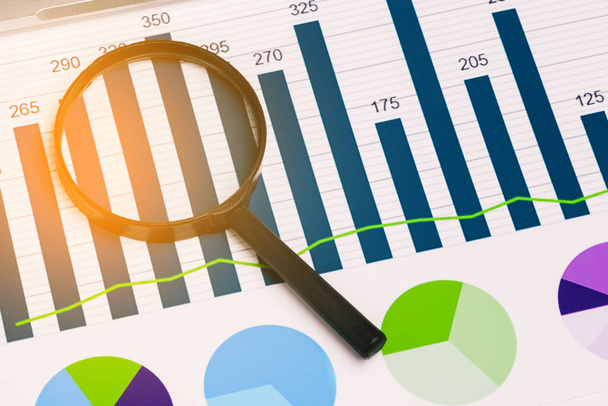 ガラス拡大鏡と財務チャート。会社のチャート。分析とマーケティング戦略と商業文書。収益と投資。レンダリング画像 - 写真・画像