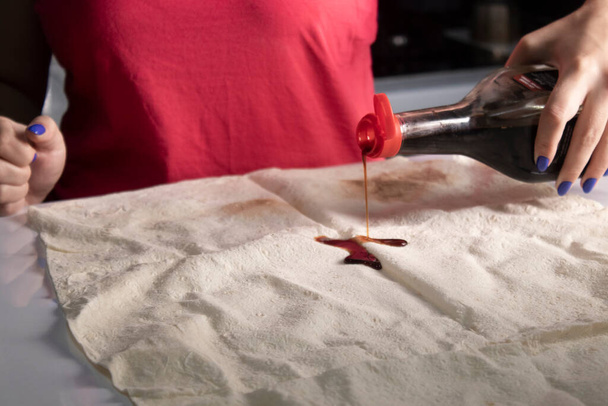 Dívčí ruce připravují chléb pita v šedé kuchyni na bílém stole. proces vaření - Fotografie, Obrázek