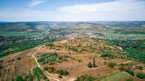 Panorama plano de la naturaleza de Moldavia, viñedos, colinas, campos, pueblo en la distancia - Foto, Imagen