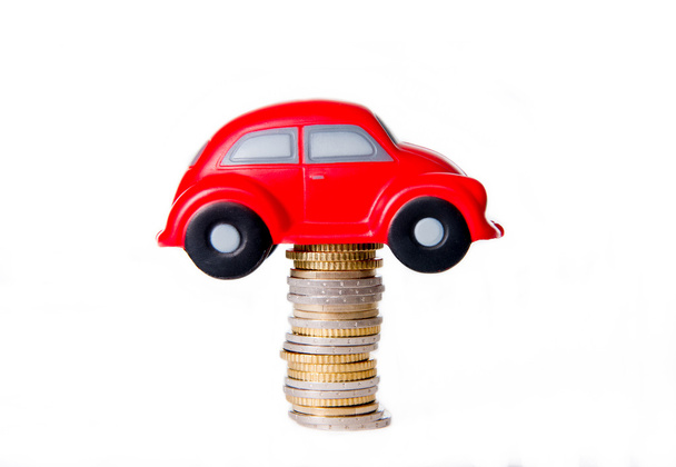 macro of a red toy car on a pile of euro coins - Foto, Bild