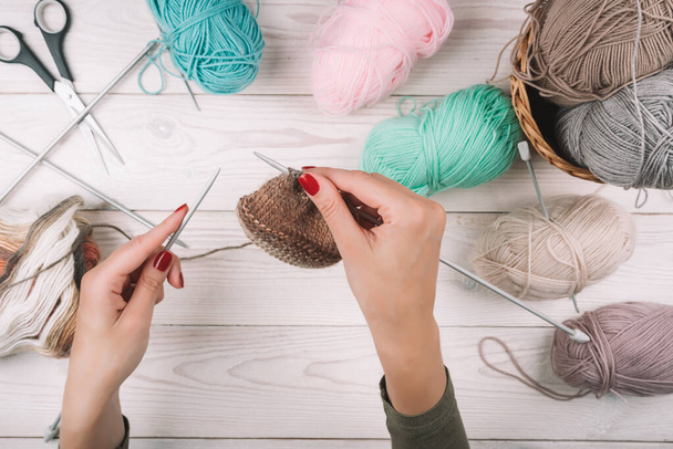 Knitting in woman hands. Close-up of hands knitting. Colorful threads. Selection of colorful yarn wool. Knitting background. Knitting yarn for handmade winter clothes. - 写真・画像