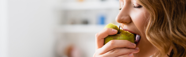 panoramic shot of woman with closed eyes eating apple - Photo, Image