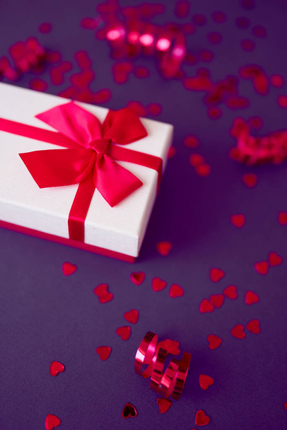 Gift box with festive ribbons on the bright purple background. - Valokuva, kuva