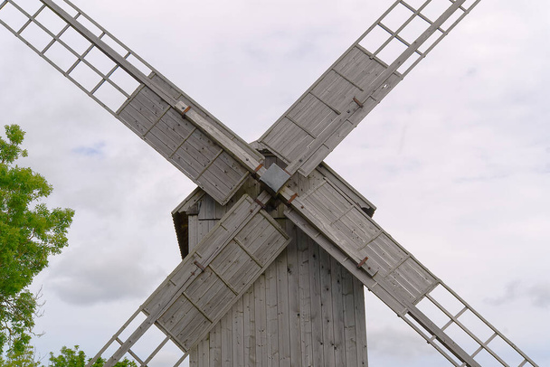 Старая винтажная деревянная мельница на фоне облачного неба. Фаземаа, Эстония. - Фото, изображение