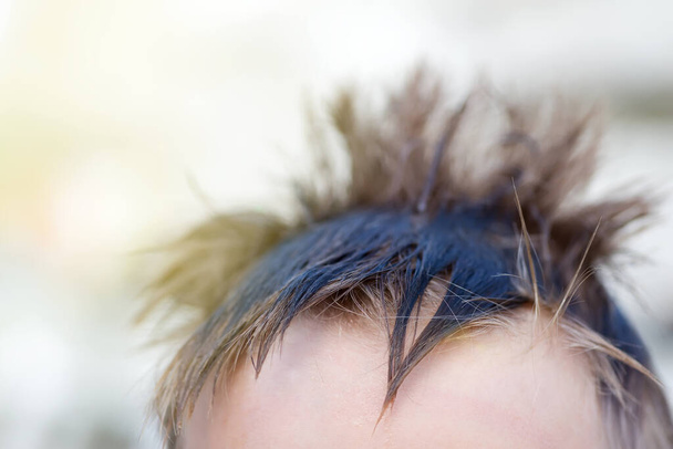 Κολλάει βρεγμένα μαλλιά στο κεφάλι ενός αγοριού.. - Φωτογραφία, εικόνα
