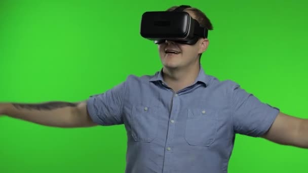 Человек, использующий шлем VR приложения, чтобы играть в симулятор, рисовать. Парень смотрит 3D видео виртуальной реальности - Кадры, видео