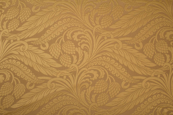 El patrón en el brocado de tela con un patrón repetitivo de flores y elementos geométricos. Color beige de la tela.Bordado con hilos metálicos - Foto, imagen