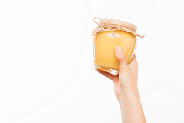 cropped view of woman holding jar of honey isolated on white, charity concept - Photo, Image