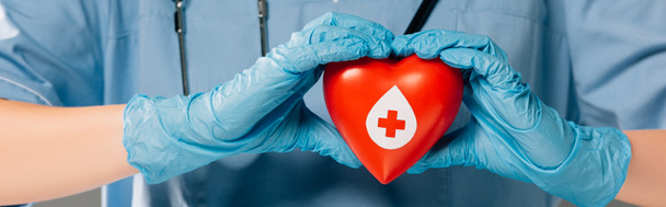 bijgesneden beeld van arts met stereoscoop houden rode hart, bloed donatie concept - Foto, afbeelding
