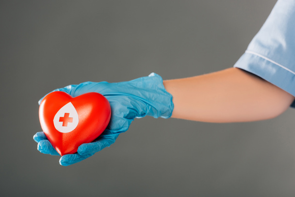 cropped view of doctor holding red heart isolated on grey, blood donation concept - Foto, Imagen