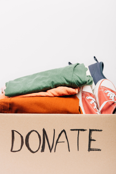 cardboard box with donated clothes and footwear isolated on white, charity concept - Photo, Image