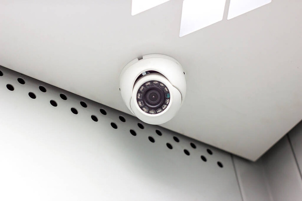 オフィスビルの天井に最新のホワイトCCTVセキュリティカメラ. - 写真・画像