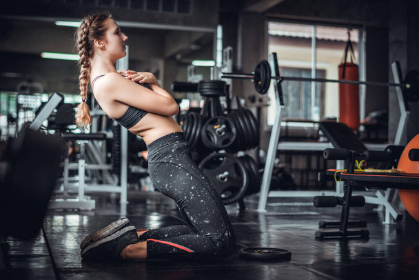 Cinematic ton młody atrakcyjny fitness kobieta ćwiczenia z maszyny w siłowni. Zdrowe, trening i dieta koncepcja stylu życia.  - Zdjęcie, obraz