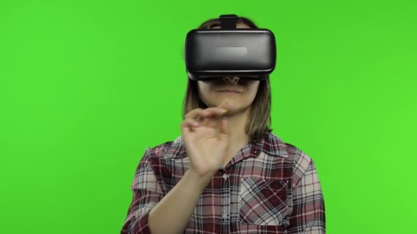 Mujer que usa casco de auriculares VR para jugar. Viendo la realidad virtual 3d 360 video. Pulsa botones - Metraje, vídeo