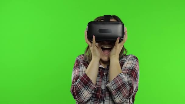 Chica usando casco de aplicación VR para jugar simulación juego de miedo. Mujer viendo vídeo realidad virtual 3D - Imágenes, Vídeo