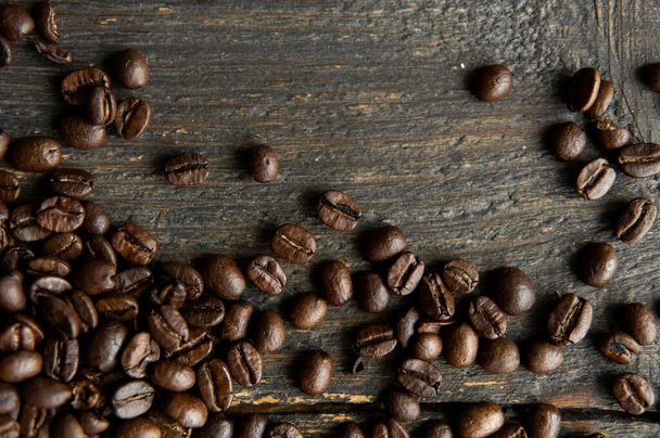 Roasted arabica coffee beans scattered on a wooden table. Fresh coffee beans. - Foto, immagini