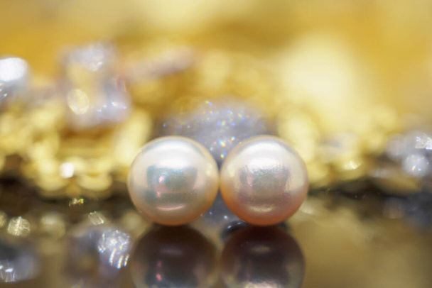 Luxusní šperky perla náušnice s odrazem na zlaté černé pozadí - Fotografie, Obrázek