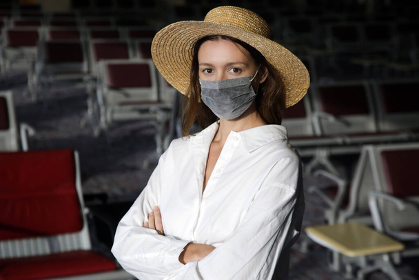 Tourist woman traveling with protective medical mask at the airport. Safety measures during coronavirus. New normal concept.  - Photo, Image
