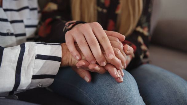 A daughter holding hands of her elderly mother. Care and support concept - Photo, Image