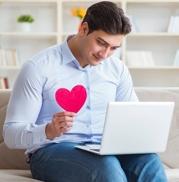 Nuori mies tekee avioliitto ehdotuksen internetissä kannettava tietokone - Valokuva, kuva