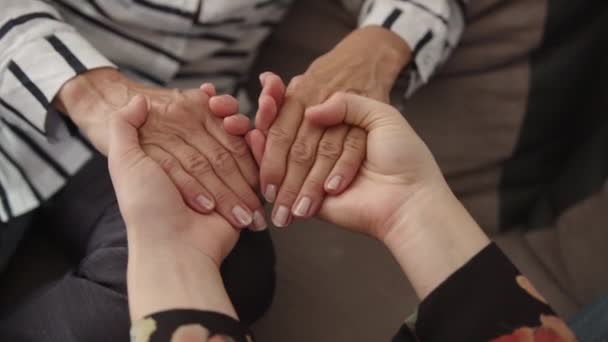 close-up volwassen bejaarde vrouw het vasthouden van handen van volwassen dochter, tonen liefde en zorg. - Video