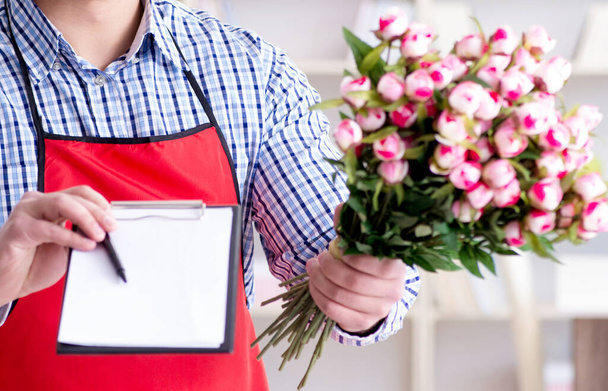 Секретарь цветочного магазина предлагает букет цветов - Фото, изображение