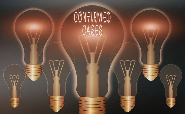 Conceptual hand writing showing Confirmed Cases. Business photo showcasing set of circumstances or conditions requiring action Realistic colored vintage light bulbs, idea sign solution. - Photo, Image