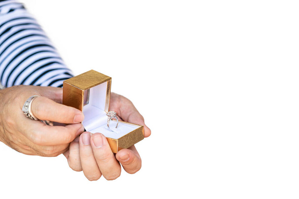 Мужчина предлагает и держать коробку с красивым и роскошным обручальным кольцом с бриллиантом на двух руках изолированы на белом фоне с обрезкой пути - Фото, изображение