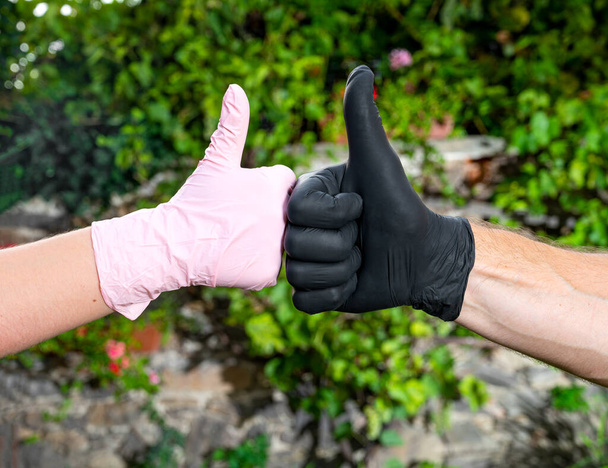 Άτομα με προστατευτικά γάντια που δείχνουν ΝΑΙ πινακίδα σε εξωτερικούς χώρους - Φωτογραφία, εικόνα