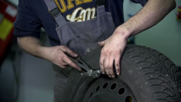 Vulkanisator hämmert Metallstück in den Reifen - Filmmaterial, Video