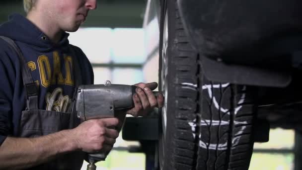 Mekaanikko löysää auton rengasta
 - Materiaali, video