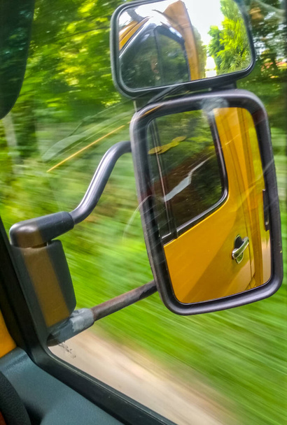 Veja através do espelho retrovisor em velocidade enquanto dirige no carro na estrada. Foto dinâmica
. - Foto, Imagem