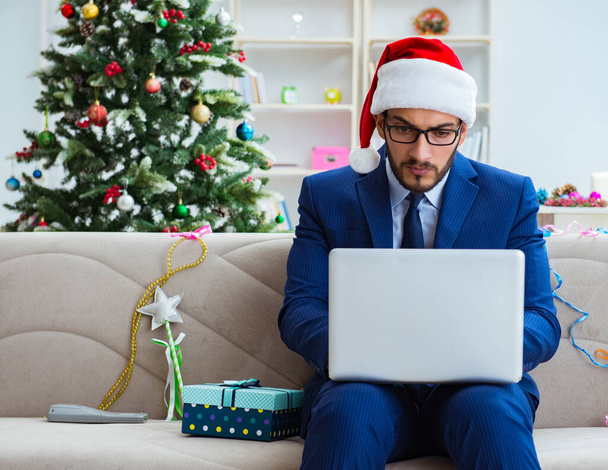 Üzletember otthon dolgozik karácsonykor - Fotó, kép