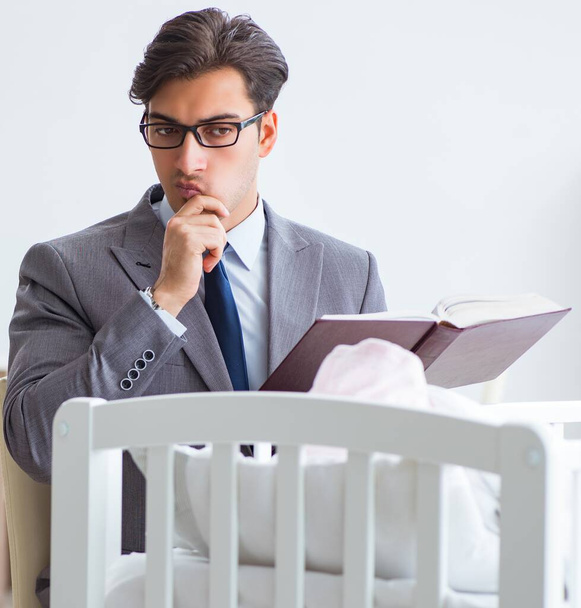 Young businessman trying to work from home caring after newborn - Photo, Image