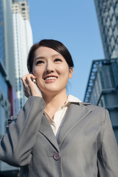 Mulher de negócios asiática feliz falando no telefone e andando no stree
 - Foto, Imagem